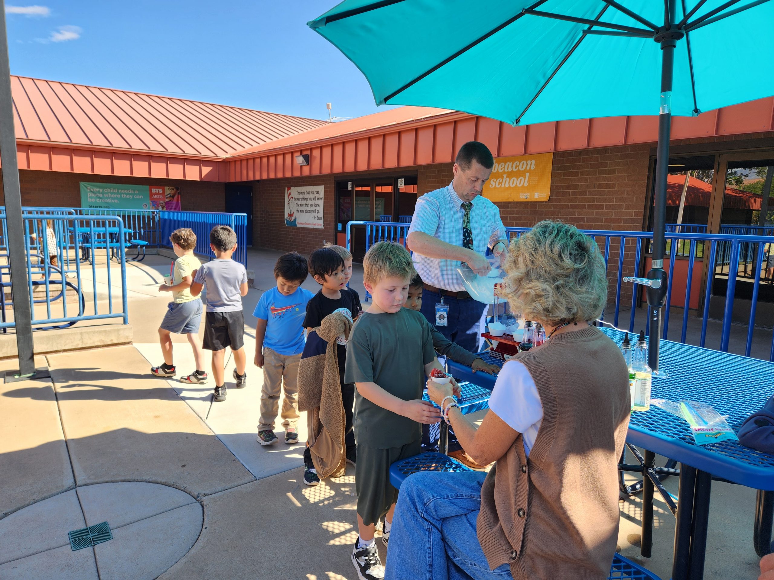 Mrs. Klein and some of her students enjoying snow cones outside the front entrance