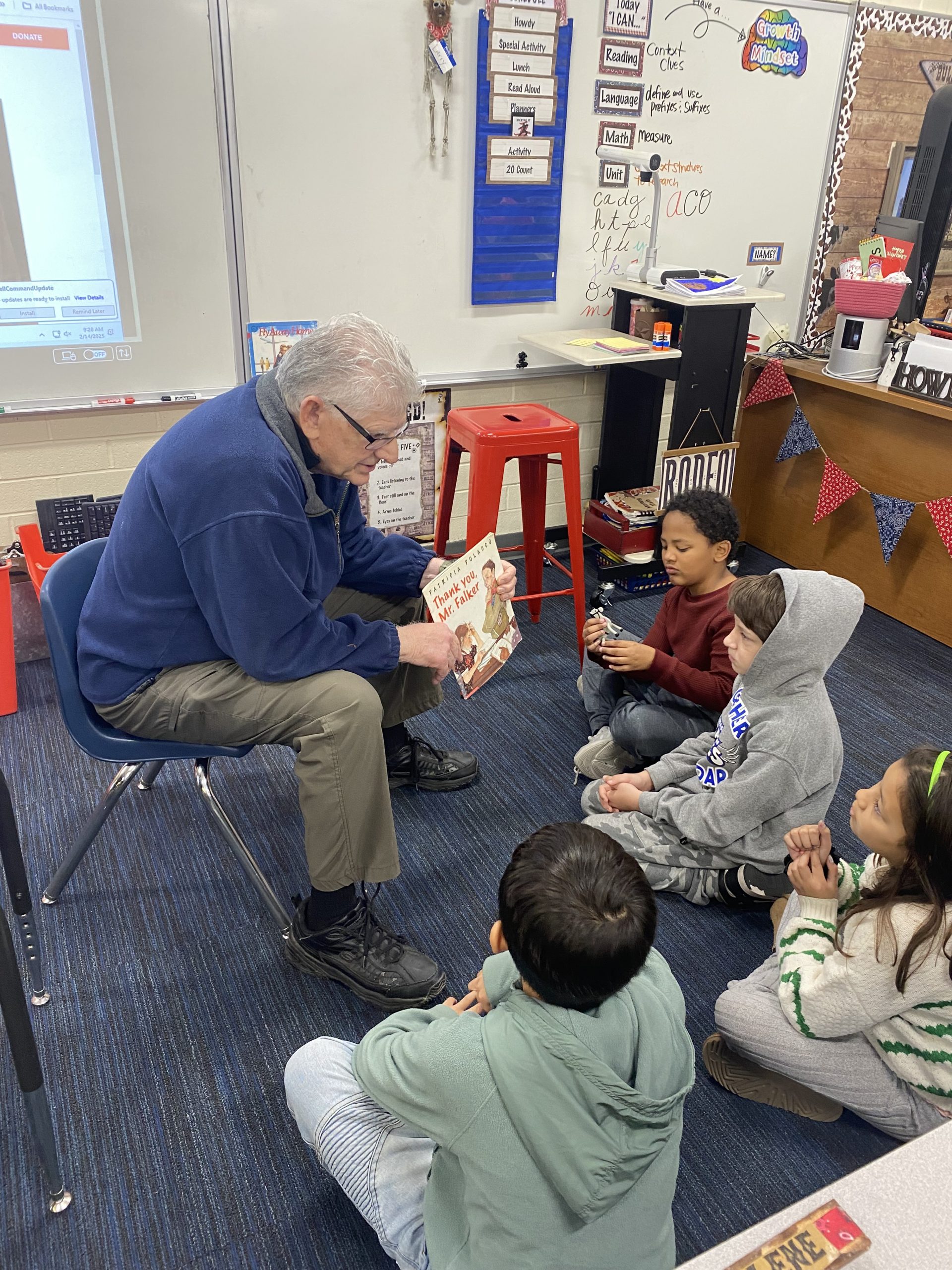 A seasoned loved one reading a book to a small group of students