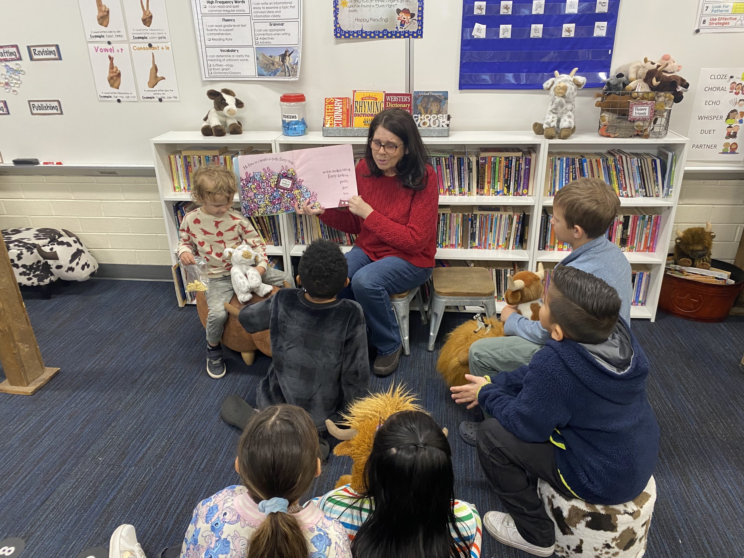 A seasoned loved one reading a book to a small group of students