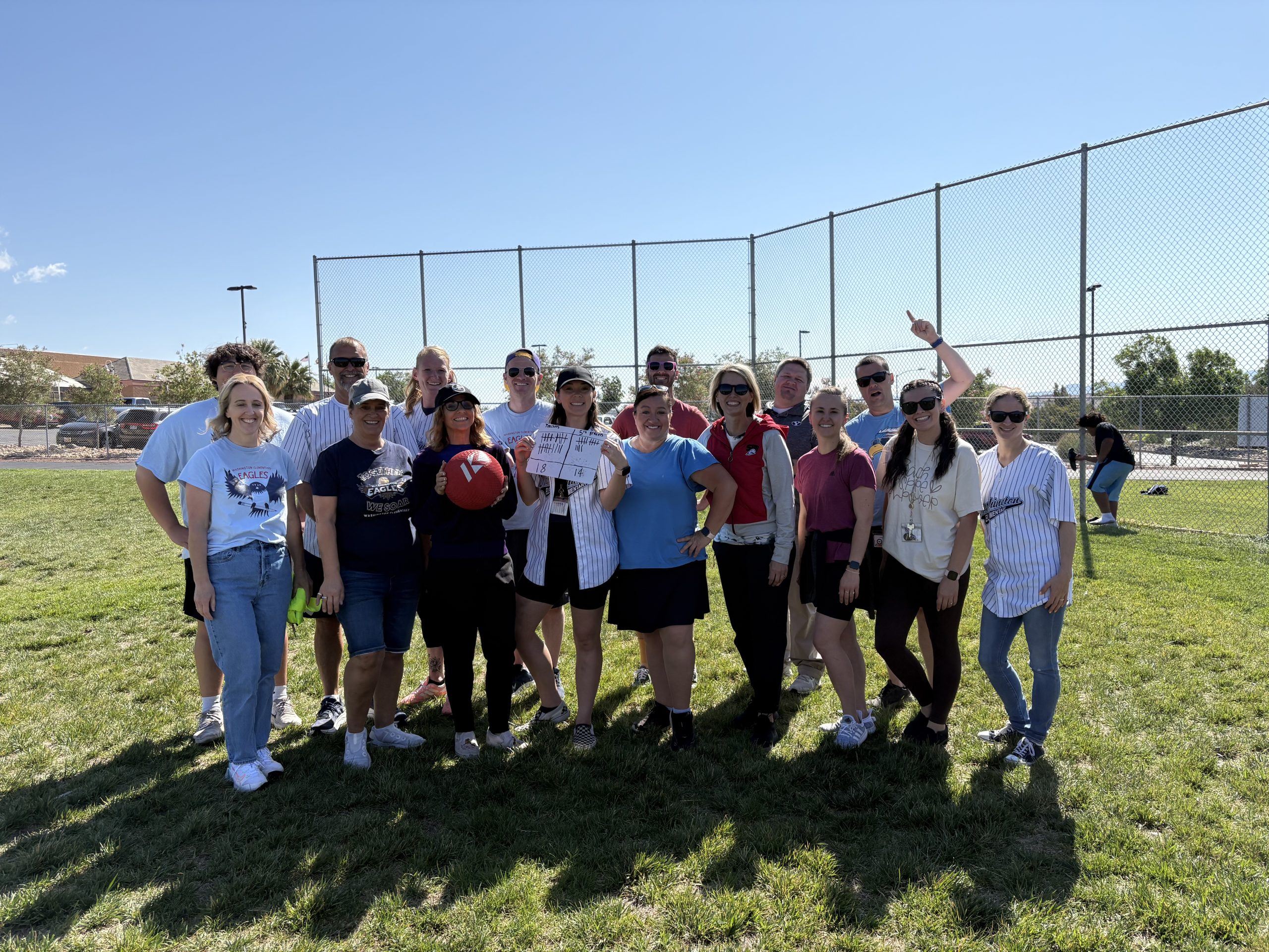 Teachers posing for a picture on the field after the kickball game.