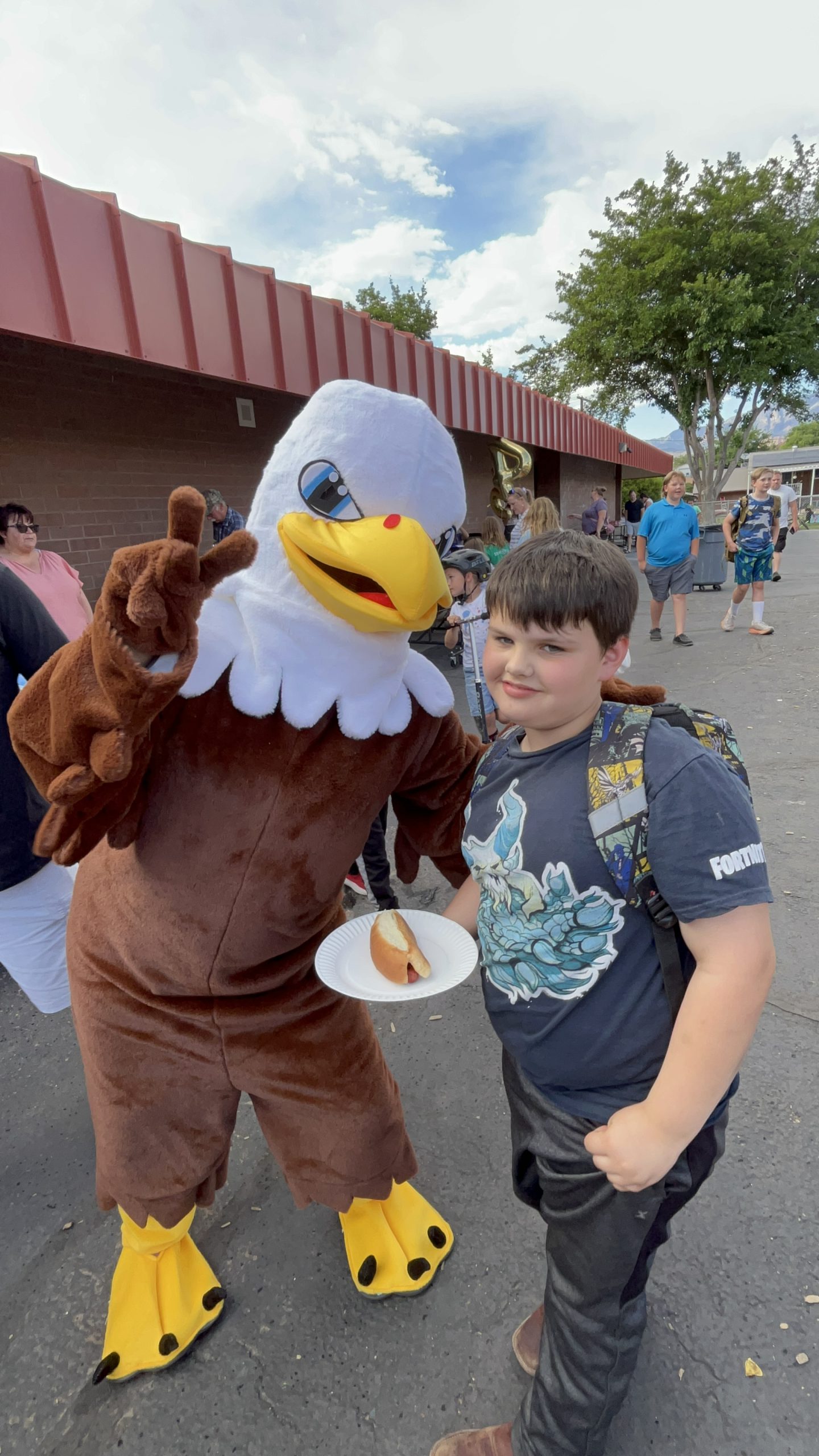 An eagle mascot and student holding a hot dog at our Hot Dog Night