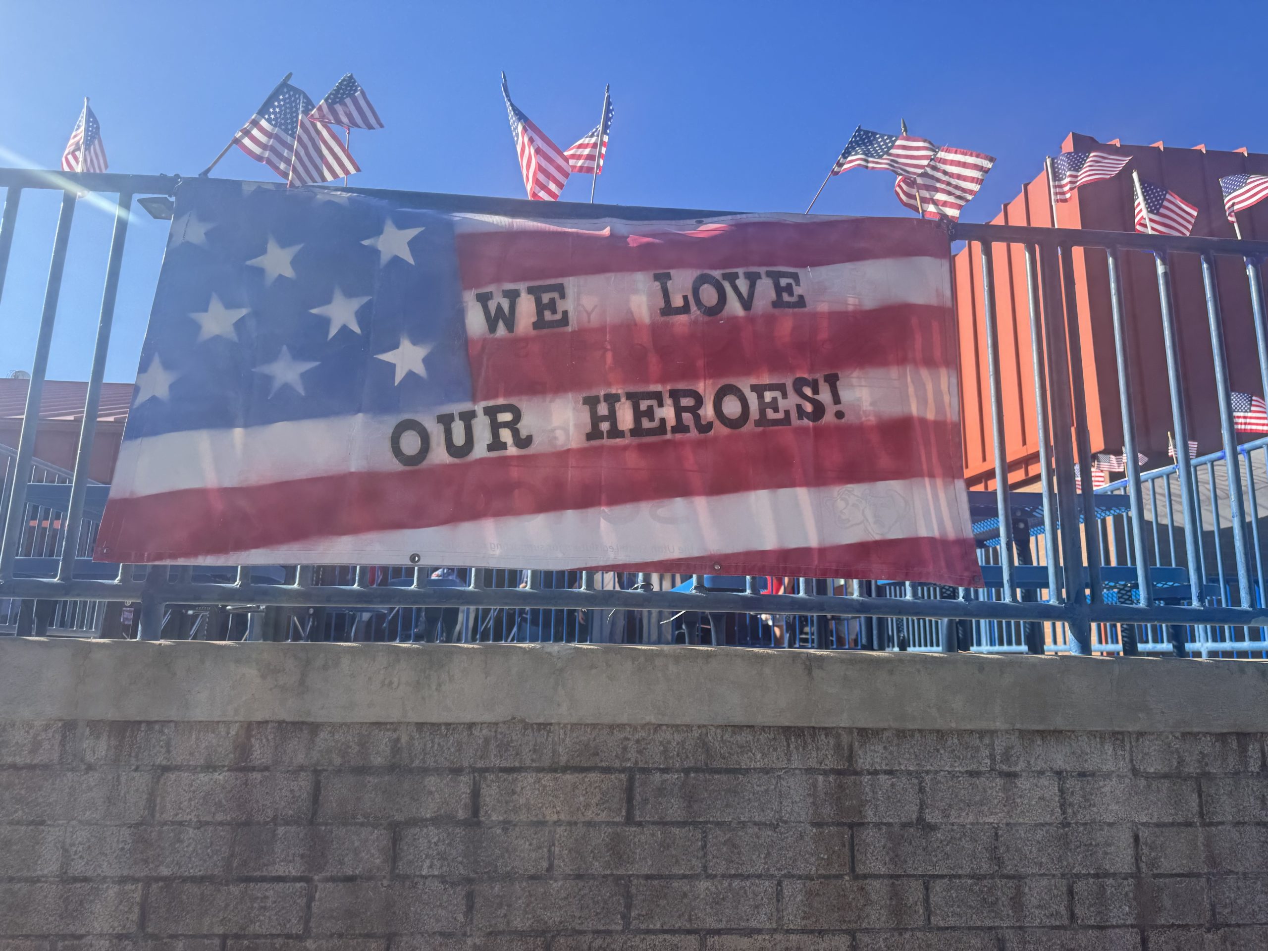 A banner hanging outside that says "We Love Our Heroes!"