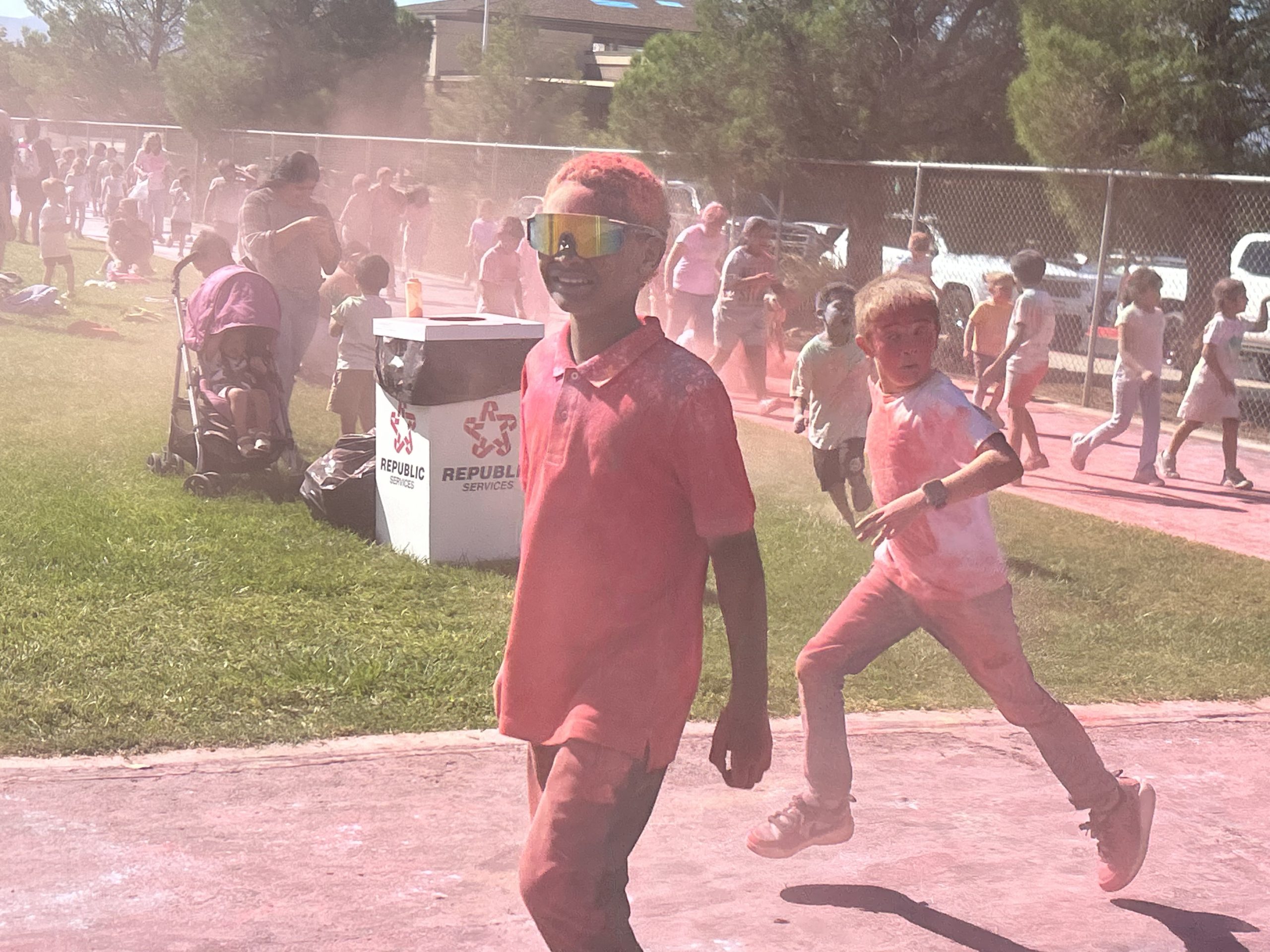 Students running around the track during the Color Run