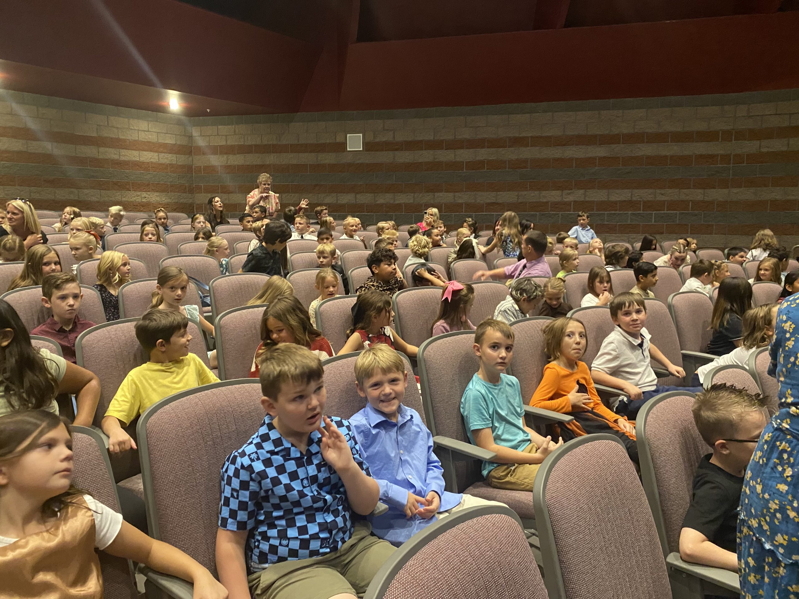 Students sitting in the auditorium waiting for the symphony to begin