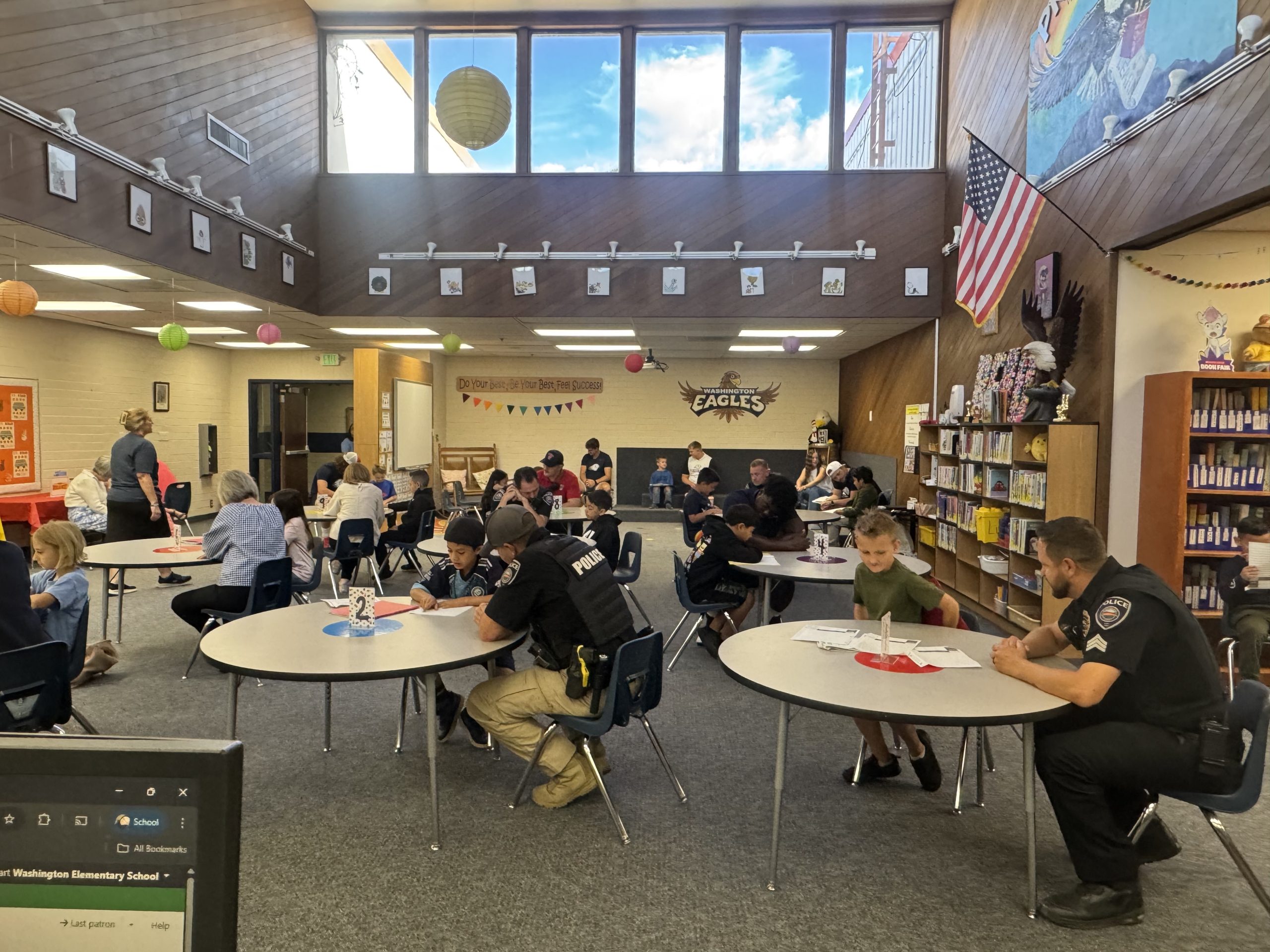 Community members and leaders reading with second graders in the Library