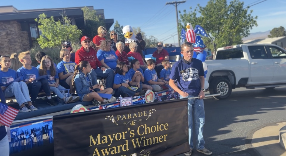 Current and former students and staff of Washington Elementary posing for a picture on our Cotton Days Parade float